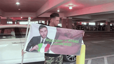 Man Holding Welcome To Vegas Flag GIF