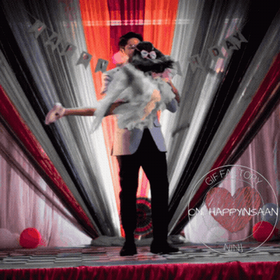 Man Holding Woman At Happy Day Sign GIF