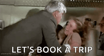 Man Holding Woman In Bed Saying Let's Book A Trip GIF