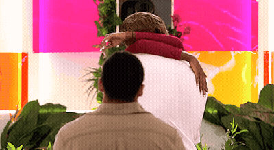 Man Holding Woman In Front Of Pink Wall GIF