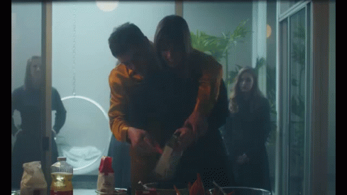 Man Holding Woman's Arm While Cooking GIF