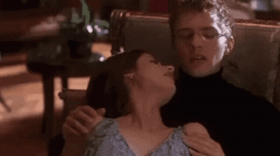 Man Holding Woman's Neck In Chair GIF