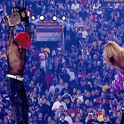 Man Holding World Heavyweight Championship In Front Of Crowd GIF
