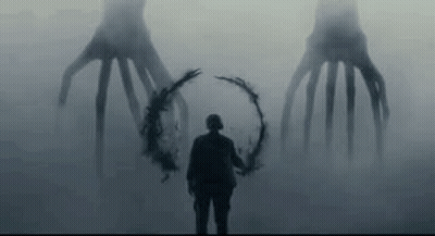 Man Holding Wreath In Front Of Monster In Fog GIF