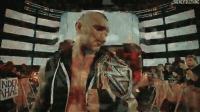 Man Holding Wrestling Championship Belt In Front Of Crowd GIF