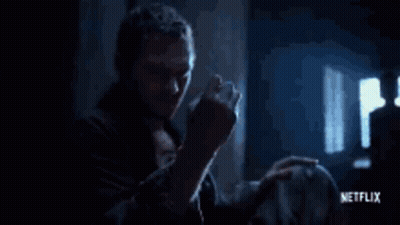 Man Holding Yellow Object In Dark Room GIF