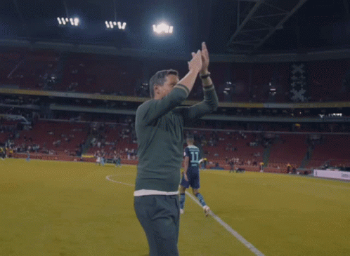 Man Hugging Man On Soccer Field With TB Shirt GIF