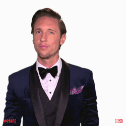 Man In A Suit Smiling Shoulder Brush GIF