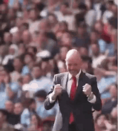Man In Adidas Shirt Smiling In Front Of Emirates Ads GIF