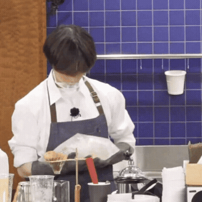 Man In Apron Holding Bag Of Food GIF