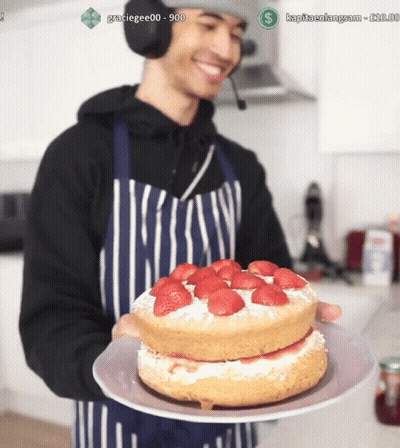 Man In Apron Holding Strawberry Cake GIF