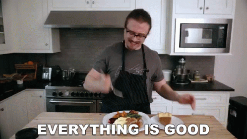 Man In Apron Standing In Kitchen With Food GIF