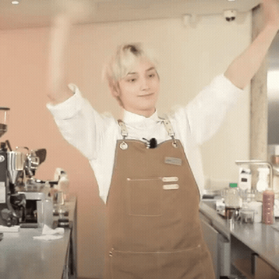 Man In Apron With Arms Up In Kitchen GIF