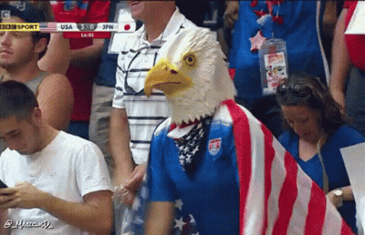 Man In Bald Eagle Mask Stands In Crowd GIF