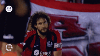 Man In Banco Jersey In Front Of Flag GIF