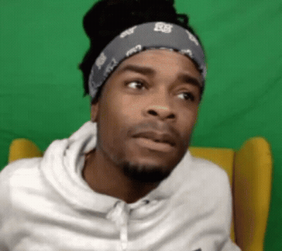 Man In Bandana And White Hoodie Sitting Before Green Screen GIF