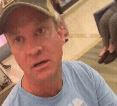 Man In Baseball Cap And Blue Shirt Looking At Camera GIF