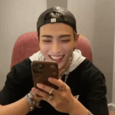 Man In Baseball Cap Laughing At Phone GIF