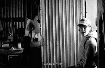 Man In Baseball Cap Standing In Front Of Door GIF