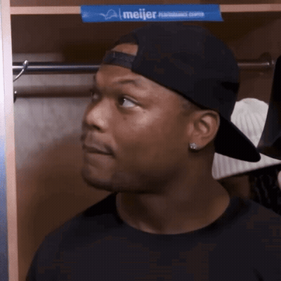 Man In Baseball Cap Standing In Locker With Meijer Advertisement GIF