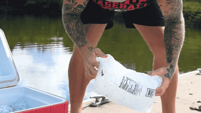Man In Baseball Shirt Holding Bag Of Ice GIF