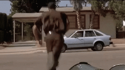 Man In Baseball Uniform Number 23 Running Down Street GIF