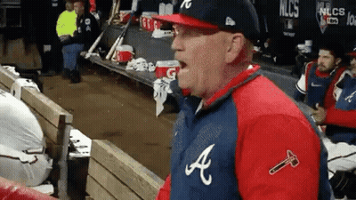 Man In Baseball Uniform Sitting In Dugout GIF
