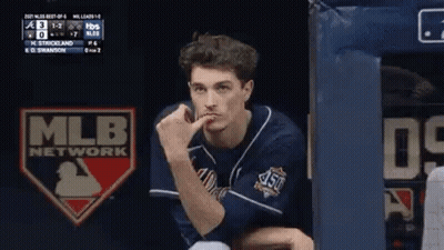 Man In Baseball Uniform Sitting In Dugout With Hand On Chin GIF
