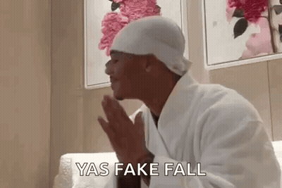 Man In Bathrobe And Hat Praying On Couch GIF