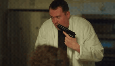 Man In Bathrobe Holding Gun GIF