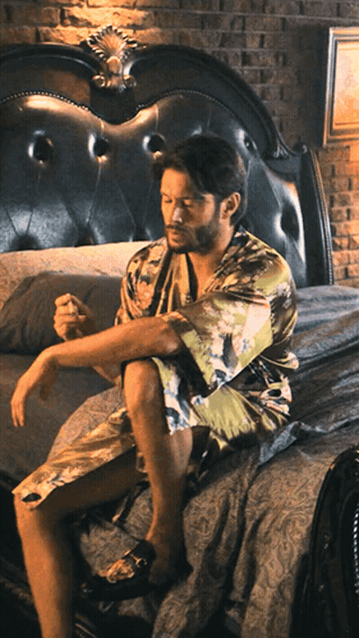 Man In Bathrobe Sitting On Bed GIF
