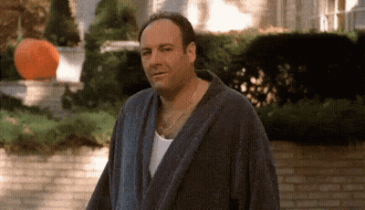 Man In Bathrobe Standing By Brick Wall GIF