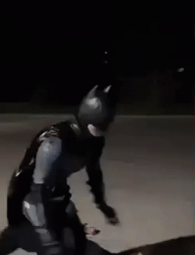 Man In Batman Costume Skateboarding At Night GIF