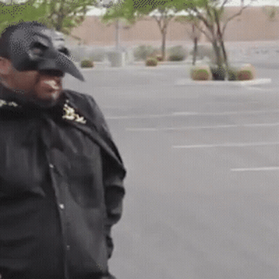 Man In Batman Mask Walking Down Parking Lot GIF