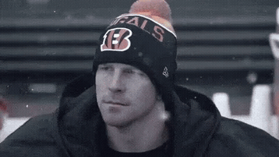 Man In Beanie And Hooded Jacket Sitting On Bench GIF