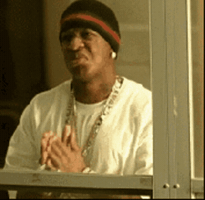 Man In Beanie And Necklace Looking Out Window GIF