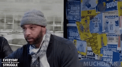 Man In Beanie And Scarf In Front Of Posters GIF