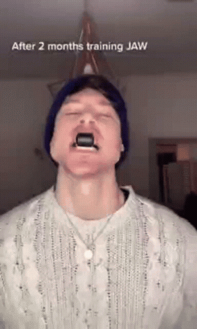 Man In Beanie And Sweater Using Jaw Trainer GIF