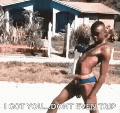 Man In Bikini Walking Down Sidewalk GIF