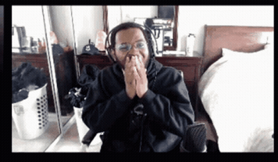 Man In Black And Gold Costume In Front Of White Building GIF