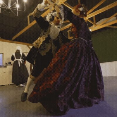 Man In Black And Gold Dancing With Woman In Purple GIF