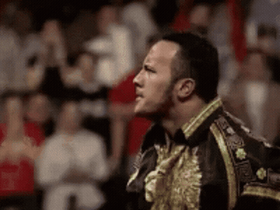 Man In Black And Gold Jacket In Front Of Crowd GIF