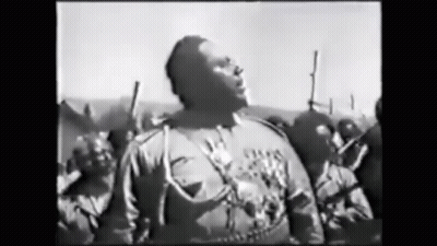 Man In Black And White Facing Armed Crowd GIF