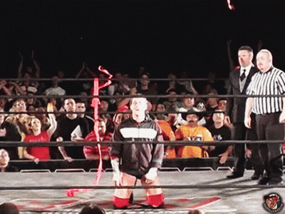 Man In Black And White Jacket In Wrestling Ring With Referees GIF