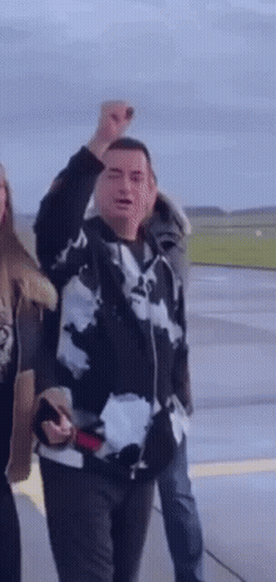 Man In Black And White Jacket Raises Fist GIF