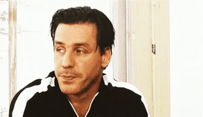 Man In Black And White Striped Shirt Looking At Camera GIF