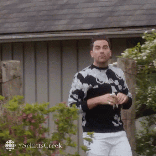 Man In Black And White Sweater And White Shorts In Front Of Building GIF