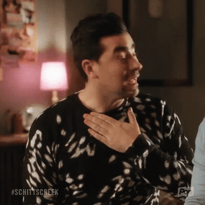 Man In Black And White Sweater Holding Hands To Chest GIF