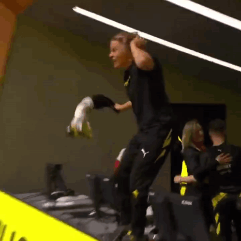 Man In Black And Yellow Puma Outfit Jumping While Holding Soccer Ball GIF