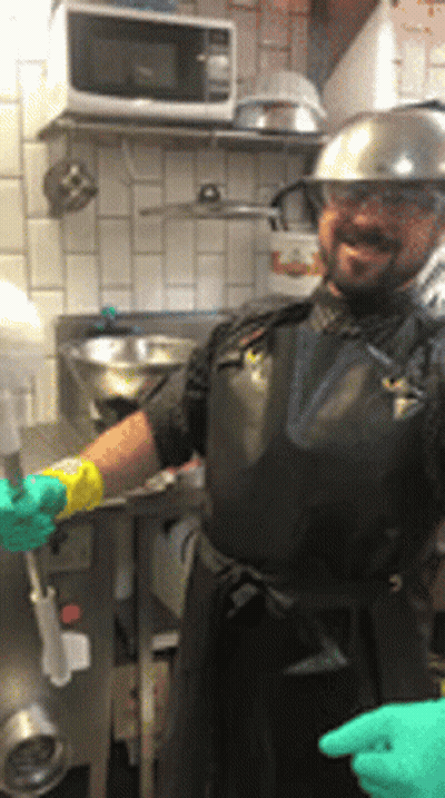 Man In Black Apron And Hard Hat In Kitchen GIF